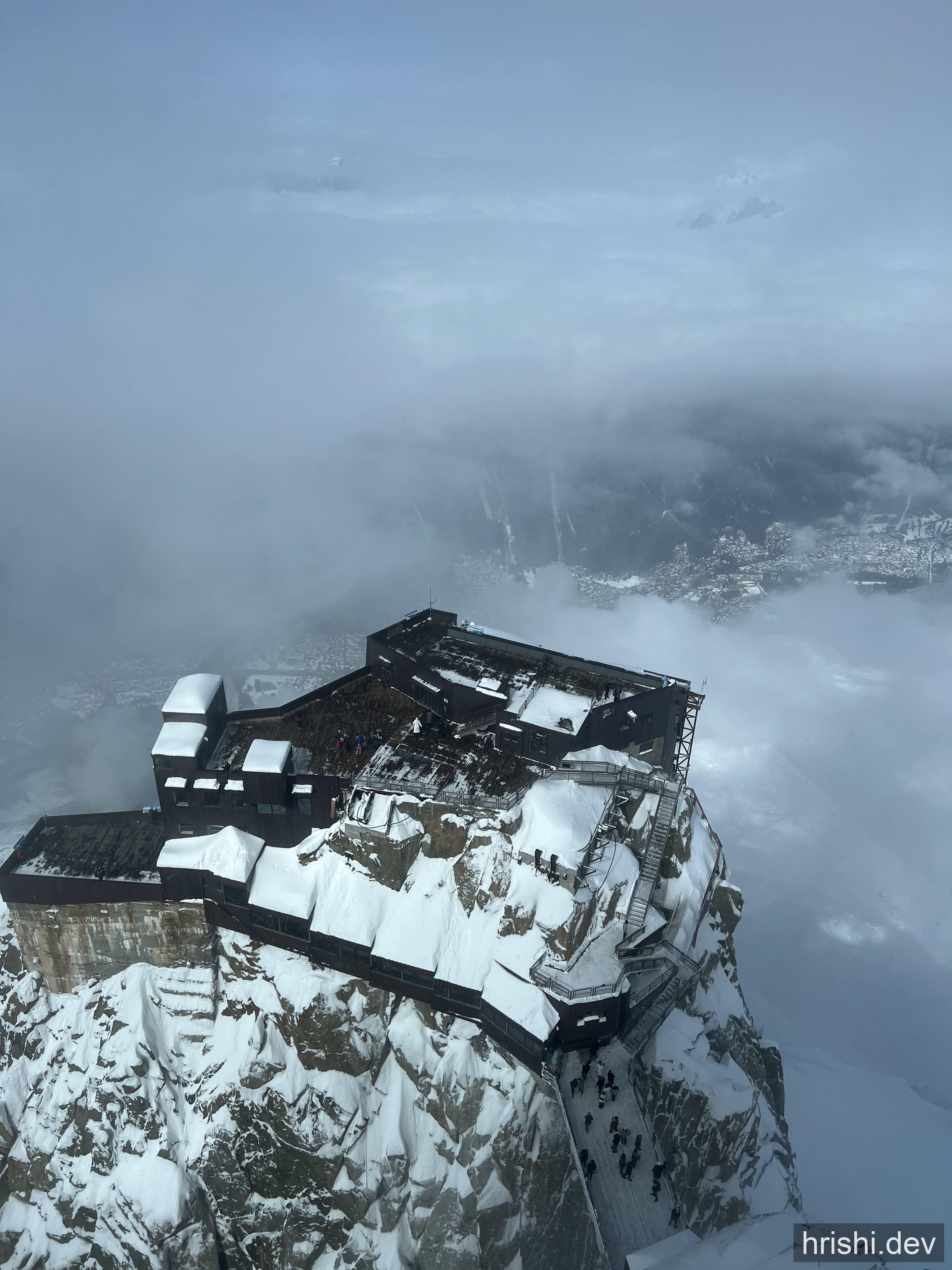 The Aiguille du Midi peak station in Chamonix, France, rising above the clouds